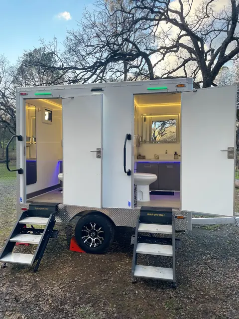 Restroom trailer lit at night at an outdoor event